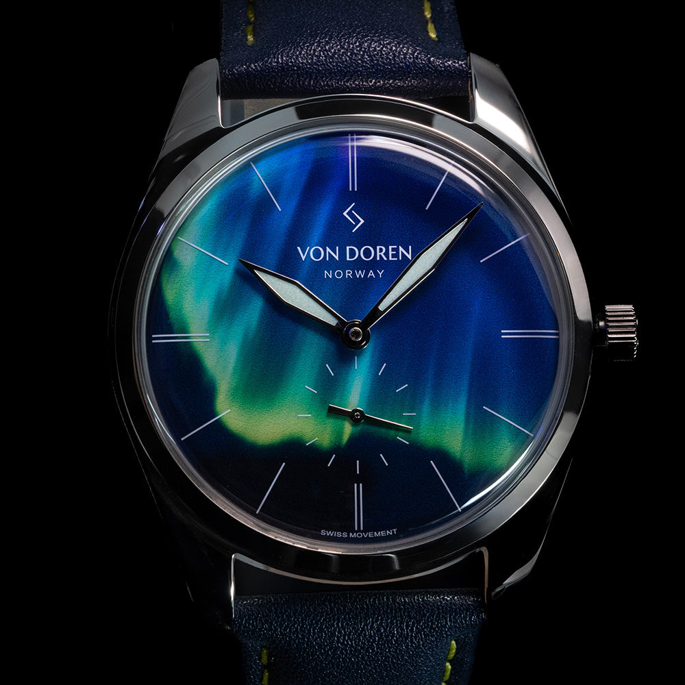 Von Doren klokke med nordlys-inspirert urskive i blått og grønt, premium nærbilde.